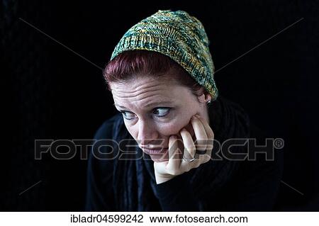 Woman in green wool hat looks disappointed against a black background View Large Photo Image Stock Image - Woman in green wool hat looks disappointed against a black background. Fotosearch
