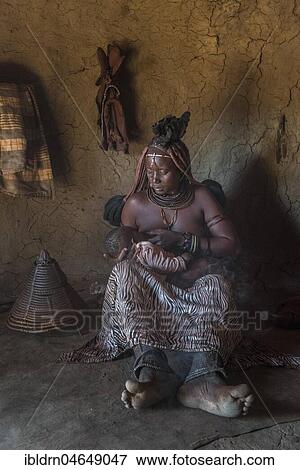 Woman of the people of Ovahimba or Himba suckling toddler in a hut, Kunene district, Namibia, Africa View Large Photo Image Stock Photo - Woman of the people of Ovahimba or Himba suckling toddler in a hut, Kunene district, Namibia, Africa. Fotosearch