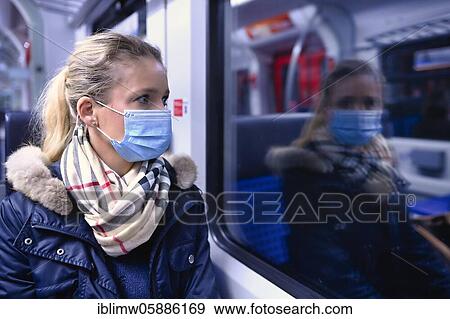 Stock Photo - Woman with a face mask sitting in a train, reflected in the S-Bahn, Corona crisis, Stuttgart, Baden-Württemberg, Germany, Europe. Fotosearch