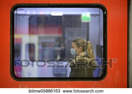 Stock Image - Woman with a face mask sitting on a train, Corona crisis, Stuttgart, Baden-Württemberg, Germany, Europe. Fotosearch