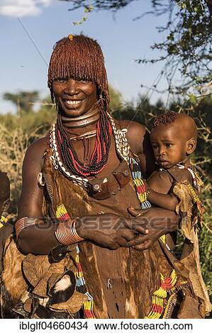 Picture - Woman with an infant in her arms, Hamer tribe, Turmi market, Southern Nations Nationalities and Peoples' Region, Ethiopia, Africa. Fotosearch