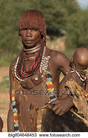 Stock Image - Woman with baby from the Hamer tribe in traditional dress, Turmi, Southern Nation Region, Ethiopia, Africa. Fotosearch