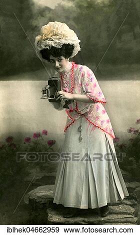 Stock Photo - Woman with camera and hat, 1910s, hand coloured, Germany, Europe. Fotosearch
