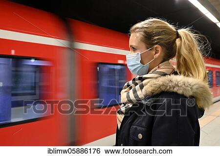 Stock Photograph - Woman with face mask waiting for train, S-Bahn, Corona crisis, Stuttgart, Baden-Württemberg, Germany, Europe. Fotosearch