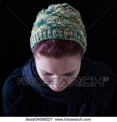 Woman with lowered head and green wool hat, against a black background View Large Photo Image Stock Photo - Woman with lowered head and green wool hat, against a black background. Fotosearch