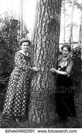 Stock Image - Women hugging a tree, 1930s, Germany, Europe. Fotosearch