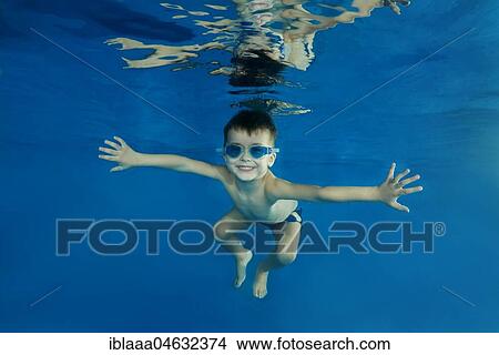 Young boy wearing swimming goggles dives in a pool View Large Photo Image Picture - Young boy wearing swimming goggles dives in a pool. Fotosearch