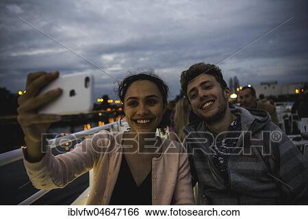 Stock Photograph - Young couple photographing themselves with a mobile phone, Smartphone, Selfie, Berlin, Germany, Europe. Fotosearch