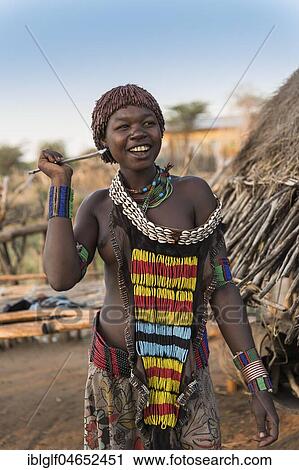Young girl in traditional dress with necklace and spear, Hamer tribe, Turmi, Region of the Southern Nations, Ethiopia, Africa View Large Photo Image Stock Image - Young girl in traditional dress with necklace and spear, Hamer tribe, Turmi, Region of the Southern Nations, Ethiopia, Africa. Fotosearch