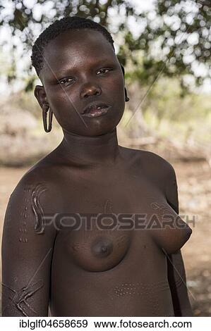 Stock Photo - Young woman with artful with decorative scars on her body, tribe of the Mursi, Southern Nations Nationalities and Peoples' Region, Ethiopia, Africa. Fotosearch