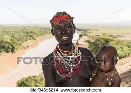 Picture - Young woman with baby, with head and necklace, check tribe, Omo River, Southern Nations Nationalities and Peoples' Region, Ethiopia, Africa. Fotosearch