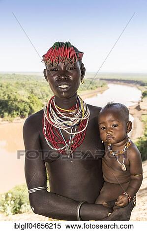Young woman with baby, with head and necklace, check tribe, Omo River, Southern Nations Nationalities and Peoples' Region, Ethiopia, Africa View Large Photo Image Stock Photography - Young woman with baby, with head and necklace, check tribe, Omo River, Southern Nations Nationalities and Peoples' Region, Ethiopia, Africa. Fotosearch