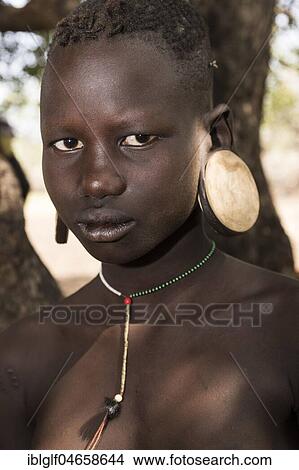 Young woman with big earplates, body jewellery, portrait, tribe of the Mursi, Southern Nations Nationalities and Peoples' Region, Ethiopia, Africa View Large Photo Image Picture - Young woman with big earplates, body jewellery, portrait, tribe of the Mursi, Southern Nations Nationalities and Peoples' Region, Ethiopia, Africa. Fotosearch