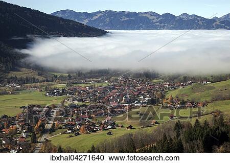 Ausblick in das Ostrachtal mit Bad Hindelang, teilweise bedeckt von Nebel, Nebelschwaden, Allgau, Bayern, Deutschland, Europa View Large Photo Image Stock Image - Ausblick in das Ostrachtal mit Bad Hindelang, teilweise bedeckt von Nebel, Nebelschwaden, Allgau, Bayern, Deutschland, Europa. Fotosearch