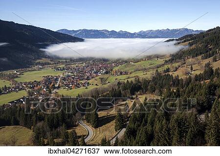Ausblick in das Ostrachtal mit Bad Hindelang, teilweise bedeckt von Nebel, Nebelschwaden, Allgau, Bayern, Deutschland, Europa View Large Photo Image Stock Photo - Ausblick in das Ostrachtal mit Bad Hindelang, teilweise bedeckt von Nebel, Nebelschwaden, Allgau, Bayern, Deutschland, Europa. Fotosearch