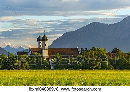 Basilika St. Benedikt, Benediktinerabtei Kloster Benediktbeuern, hinten rechts Herzogstand und Heimgarten der Voralpen, ganz hinten Arnspitzgruppe im Wettersteingebirge der Alpen, Benediktbeuern, Oberbayern, Bayern, Deutschland, Europa View Large Photo Image Stock Photo - Basilika St. Benedikt, Benediktinerabtei Kloster Benediktbeuern, hinten rechts Herzogstand und Heimgarten der Voralpen, ganz hinten Arnspitzgruppe im Wettersteingebirge der Alpen, Benediktbeuern, Oberbayern, Bayern, Deutschland, Europa. Fotosearch