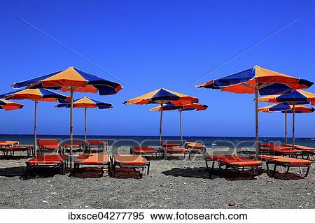 Stock Photography - Bunte Liegestuhle und Sonnenschirme am Strand mit blauem Meer, Kreta, Griechenland, Europa. Fotosearch