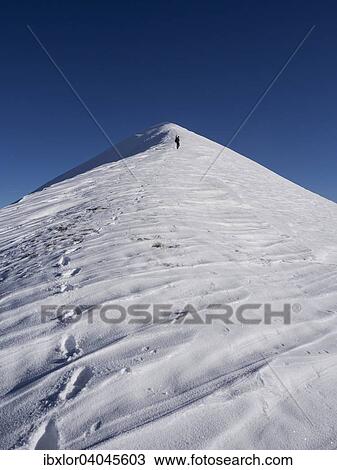 Stock Image - Ein Alpinist besteigt den Monte Motette, an einem Wintertag mit blauem Himmel, Monte Cucco Regionalpark, Umbrien, Italien, Europa. Fotosearch