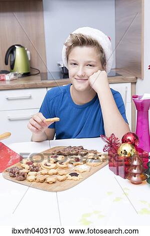 Ein Junge sitzt in der Kuche und geniesst frisch-gebackene Weihnachtsplatzchen View Large Photo Image Stock Image - Ein Junge sitzt in der Kuche und geniesst frisch-gebackene Weihnachtsplatzchen. Fotosearch