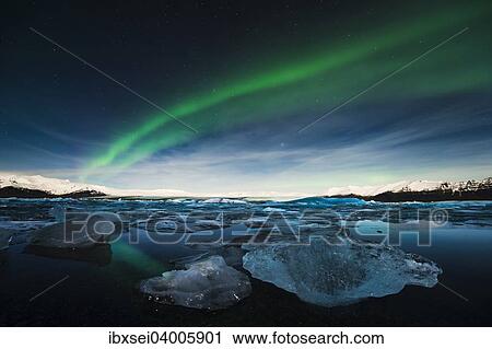 Stock Image - Eisbrocken im Wasser zur blauen Stunde mit Polarlicht, See Jokulsarlon, Vik, Island, Europa. Fotosearch
