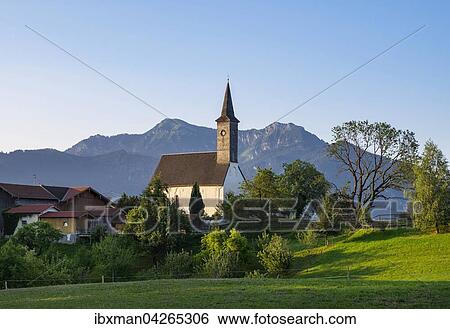 Stock Photograph - Filialkirche St. Peter und Paul, Westerbuchberg, Gemeinde Ubersee, hinten Hochgern und Zwolferspitz in Chiemgauer Alpen, Chiemgau, Oberbayern, Bayern, Deutschland, Europa. Fotosearch