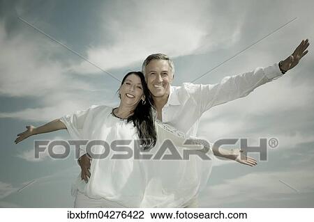 Stock Image - Frau und Mann im mittleren Alter, glucklich und beschwingt, Deutschland, Europa. Fotosearch