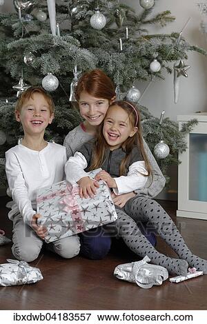 Heiligabend, Geschwister freuen sich uber Weihnachtsgeschenke unter dem Weihnachtsbaum, Bayern, Deutschland, Europa View Large Photo Image Stock Photo - Heiligabend, Geschwister freuen sich uber Weihnachtsgeschenke unter dem Weihnachtsbaum, Bayern, Deutschland, Europa. Fotosearch