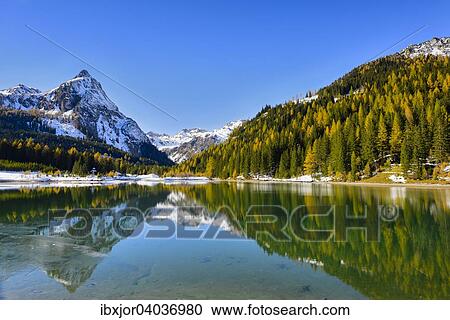 Stock Image - Herbst im Naturpark Riedingtal, Schliereralm, Schlierersee, Spiegelung Riedingspitze, Herbstverfarbung der Larchen, erster Schnee, Zederhaus, Lungau, Salzburg, Osterreich, Europa. Fotosearch
