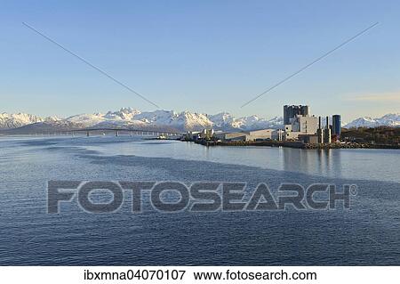 Stock Photo - Industrieanlage am blauen Langoysund, hinten die schneebedeckten Gipfel von Hinnoya, Stokmarknes, Nordland, Vesteralen, Norwegen, Europa. Fotosearch