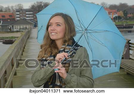 Junge Frau mit blauem Regenschirm im Herbst, Ystad, Schweden, Europa View Large Photo Image Stock Image - Junge Frau mit blauem Regenschirm im Herbst, Ystad, Schweden, Europa. Fotosearch