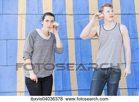 Junge Frau und junger Mann mit einem Dosentelefon, beide horen zu, Symbolbild, Kommunikation in einer Beziehung View Large Photo Image Stock Photo - Junge Frau und junger Mann mit einem Dosentelefon, beide horen zu, Symbolbild, Kommunikation in einer Beziehung. Fotosearch
