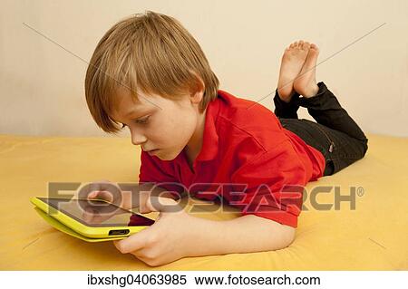 Junge spielt mit Tablet-PC View Large Photo Image Stock Photography - Junge spielt mit Tablet-PC. Fotosearch