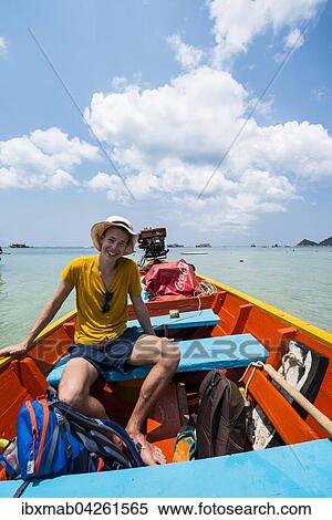 Junger Mann sitzt in einem Longtail-Boot, turkises Meer, Insel Koh Tao, Golf von Thailand, Thailand, Asien View Large Photo Image Stock Photography - Junger Mann sitzt in einem Longtail-Boot, turkises Meer, Insel Koh Tao, Golf von Thailand, Thailand, Asien. Fotosearch