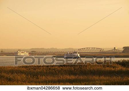 Lagune Barther Bodden mit Meiningenbrucke und Ausflugsboote im Abendlicht, Fischland-Darss-Zingst, Nationalpark Vorpommersche Boddenlandschaft, Mecklenburg-Vorpommern, Deutschland, Europa View Large Photo Image Stock Photo - Lagune Barther Bodden mit Meiningenbrucke und Ausflugsboote im Abendlicht, Fischland-Darss-Zingst, Nationalpark Vorpommersche Boddenlandschaft, Mecklenburg-Vorpommern, Deutschland, Europa. Fotosearch