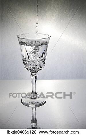 Mehrere Tropfen fallen in ein Glas mit Wasser View Large Photo Image Stock Photo - Mehrere Tropfen fallen in ein Glas mit Wasser. Fotosearch