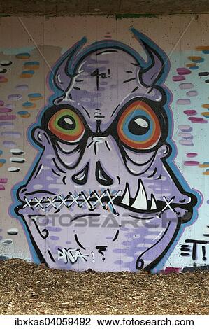 Stock Image - Monster mit Hornern und zugenahtem Mund, Wandbild, Streetart, Dusseldorf, Nordrhein-Westfalen, Deutschland, Europa. Fotosearch