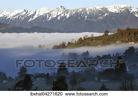 Morgennebel liegt uber dem Ostrachtal und Bad Hindelang, hinten die Allgauer Berge, Allgau, Bayern, Deutschland, Europa View Large Photo Image Stock Image - Morgennebel liegt uber dem Ostrachtal und Bad Hindelang, hinten die Allgauer Berge, Allgau, Bayern, Deutschland, Europa. Fotosearch