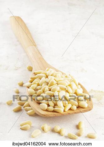 Picture - Pinienkerne auf einem Holzloffel. Fotosearch