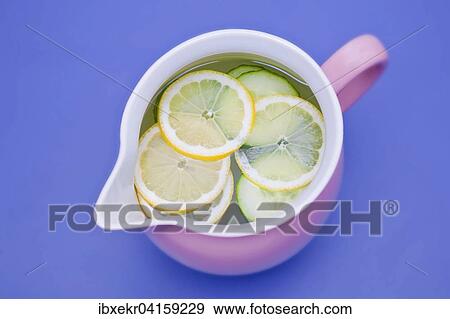 Stock Photo - Porzellankrug mit Wasser, Zitronenscheiben, Gurkenscheiben, Erfrischungsgetrank. Fotosearch