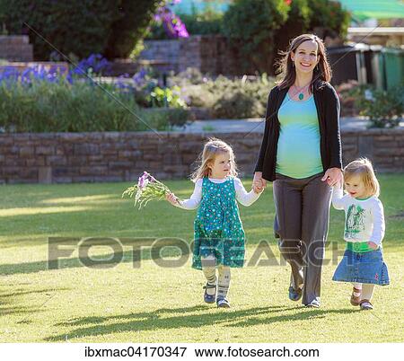 Schwangere Frau lauft mit ihren Tochtern uber eine Wiese im Park, Tintenpalast, Windhoek, Namibia, Afrika View Large Photo Image Stock Photo - Schwangere Frau lauft mit ihren Tochtern uber eine Wiese im Park, Tintenpalast, Windhoek, Namibia, Afrika. Fotosearch