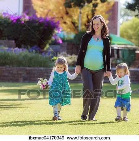 Schwangere Frau lauft mit ihren Tochtern uber eine Wiese im Park, Tintenpalast, Windhoek, Namibia, Afrika View Large Photo Image Stock Photo - Schwangere Frau lauft mit ihren Tochtern uber eine Wiese im Park, Tintenpalast, Windhoek, Namibia, Afrika. Fotosearch