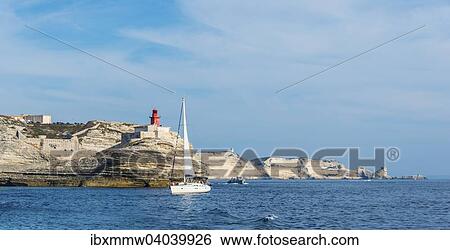 Stock Photograph - Segelboot vor Kreidefelsen und Leuchtturm, Bonifacio, Korsika, Frankreich, Europa. Fotosearch