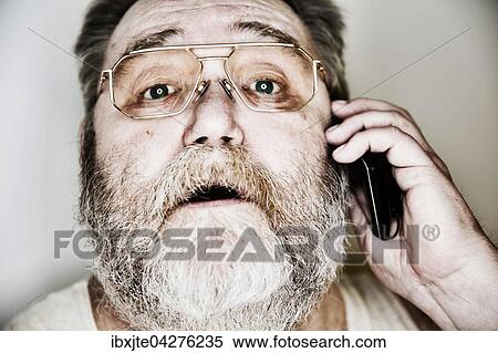 Senior mit Vollbart und Brille im Unterhemd telefoniert mit seinem Smartphone, Portrait, Deutschland, Europa View Large Photo Image Stock Photography - Senior mit Vollbart und Brille im Unterhemd telefoniert mit seinem Smartphone, Portrait, Deutschland, Europa. Fotosearch