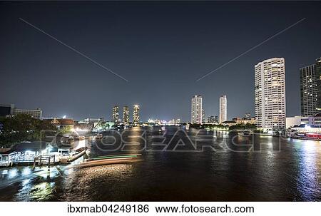 Stock Photograph - Skyline mit Booten auf dem Fluss Mae Nam Chao Phraya bei Nacht, Bangkok, Thailand, Asien. Fotosearch