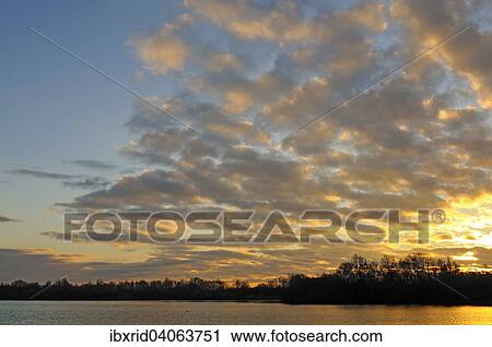 Sonnenaufgang mit Wolken am See in Menzelen, Nordrhein-Westfalen, Deutschland, Europa View Large Photo Image Stock Image - Sonnenaufgang mit Wolken am See in Menzelen, Nordrhein-Westfalen, Deutschland, Europa. Fotosearch