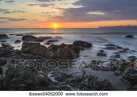 Stock Image - Sonnenuntergang am Pazifik, Felsen von Wasser umspult, hinten Halbinsel Osa, Golfo Dulce, Provinz Puntarenas, Costa Rica, Nordamerika. Fotosearch