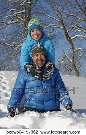 Stock Image - Vater und Sohn toben im Schnee, Bad Heilbrunn, Oberbayern, Bayern, Deutschland, Europa. Fotosearch