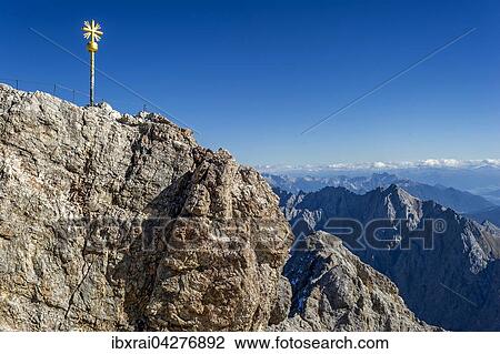 Vergoldetes Gipfelkreuz am Gipfel der Zugspitze, hinten Ausblick nach Tirol, Garmisch-Partenkirchen, Wettersteingebirge, Ostalpen, Oberbayern, Bayern, Deutschland, Europa View Large Photo Image Stock Image - Vergoldetes Gipfelkreuz am Gipfel der Zugspitze, hinten Ausblick nach Tirol, Garmisch-Partenkirchen, Wettersteingebirge, Ostalpen, Oberbayern, Bayern, Deutschland, Europa. Fotosearch