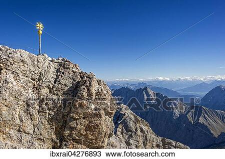 Vergoldetes Gipfelkreuz am Gipfel der Zugspitze, hinten Mieminger Gebirge in Tirol, Garmisch-Partenkirchen, Wettersteingebirge, Ostalpen, Oberbayern, Bayern, Deutschland, Europa View Large Photo Image Stock Image - Vergoldetes Gipfelkreuz am Gipfel der Zugspitze, hinten Mieminger Gebirge in Tirol, Garmisch-Partenkirchen, Wettersteingebirge, Ostalpen, Oberbayern, Bayern, Deutschland, Europa. Fotosearch
