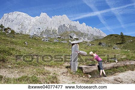 Stock Photo - Wanderin erfrischt sich bei einem Brunnen, Almlandschaft, Hochkonig, Muhlbach am Hochkonig, Land Salzburg, Osterreich, Europa. Fotosearch